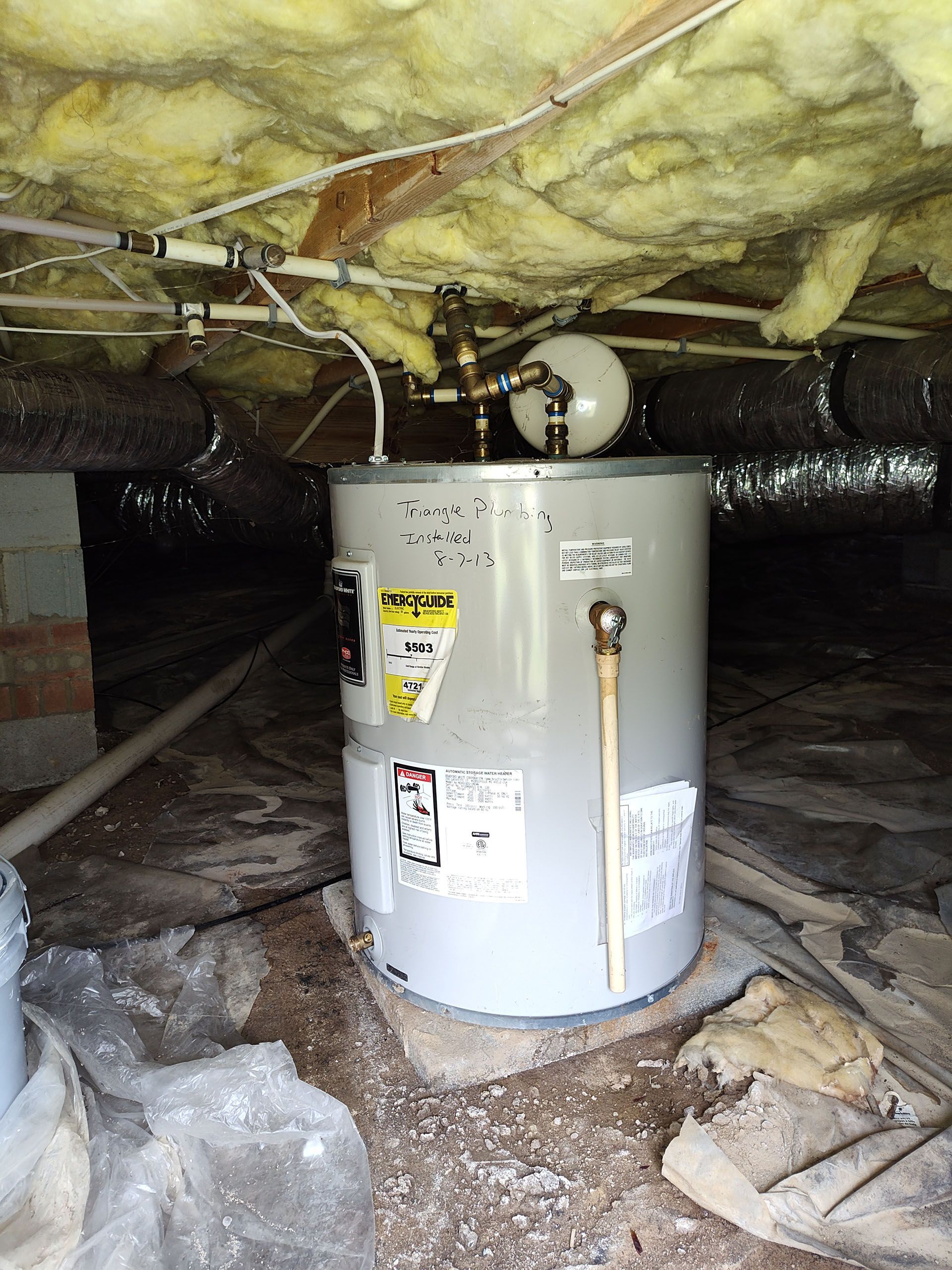 A water heater is sitting in a basement.