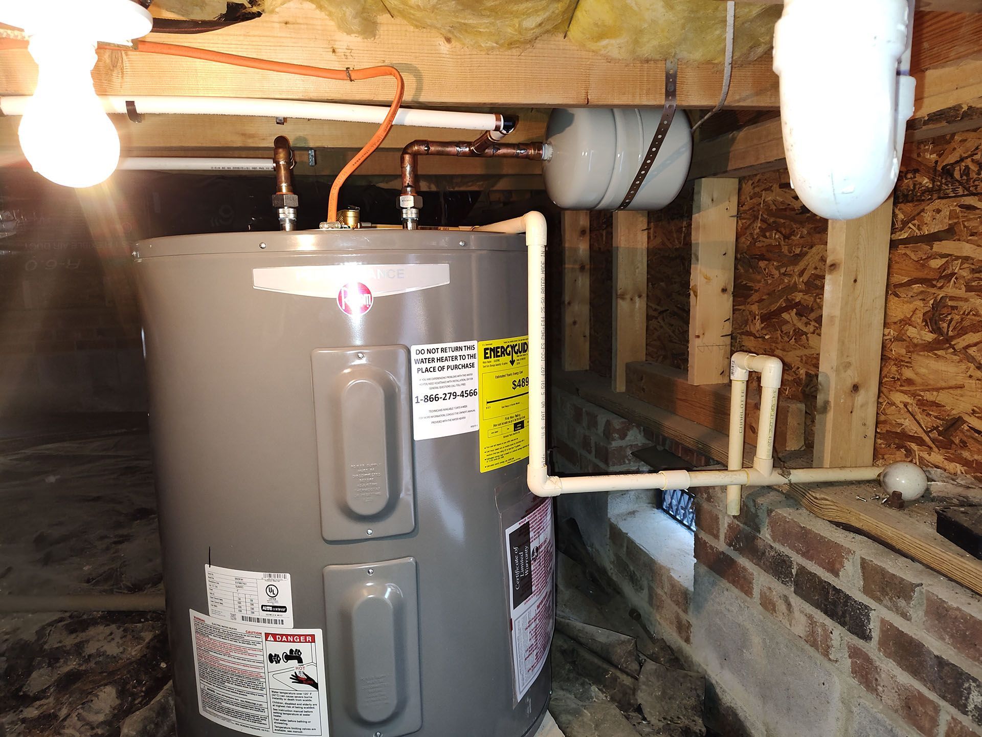 A water heater is sitting in a basement.
