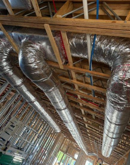 Framed ceiling with insulated HVAC ducts and plumbing.