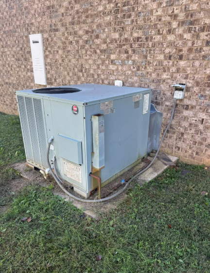 Gray air conditioning unit outside a brick building.