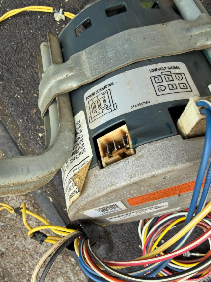 Damaged HVAC motor with charred power connector and wiring.