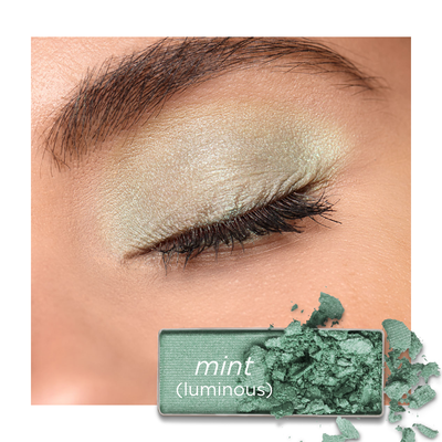 An eye with shimmery mint-green eyeshadow, next to a swatch of the same luminous mint-green powder