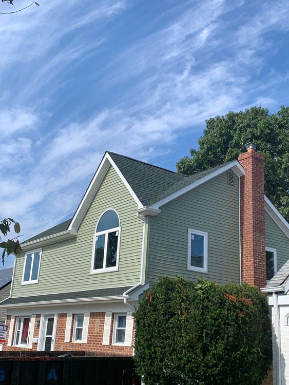 a large house with a green siding