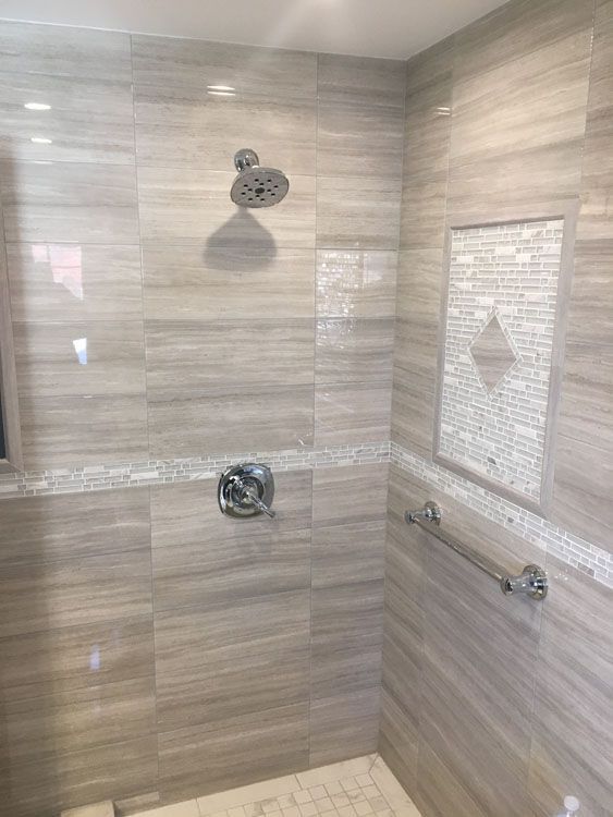a bathroom with a walk-in shower and a hand rail