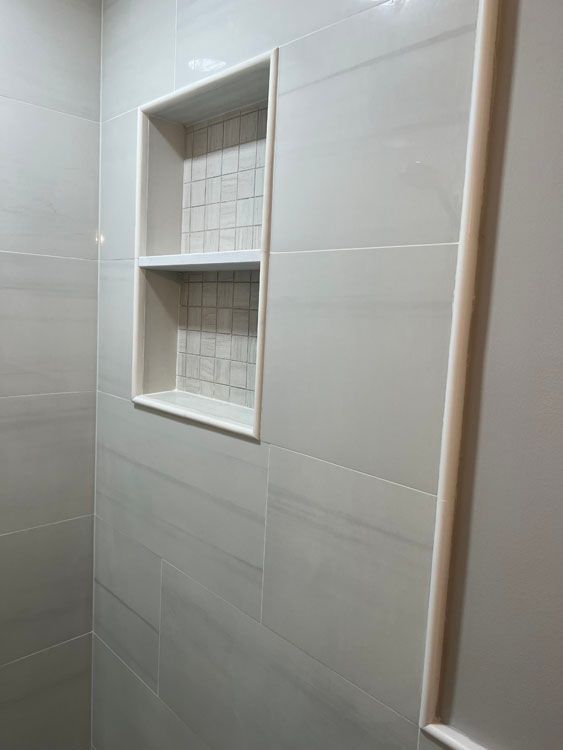 a shower stall with a shelf on the wall