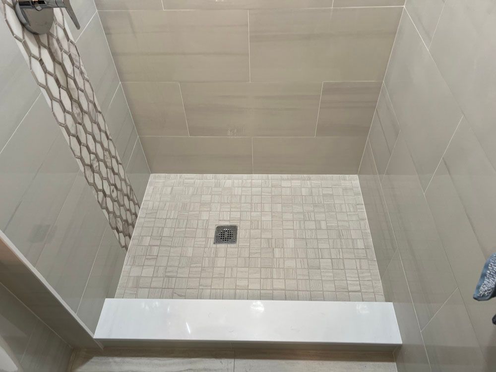 a bathroom with a walk in shower with a tiled floor