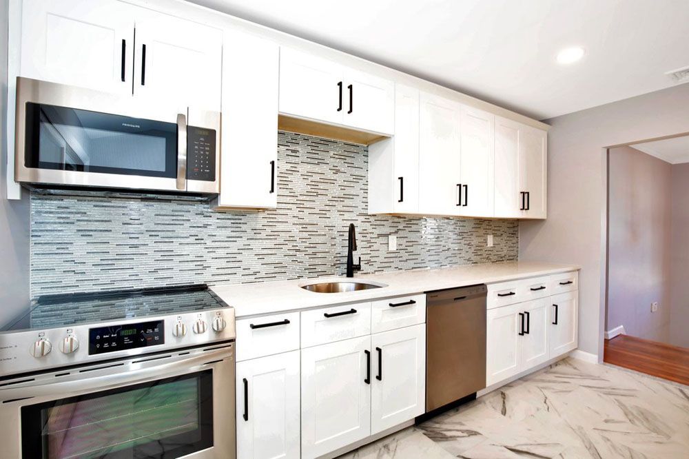 a kitchen with white cabinets and stainless steel appliances