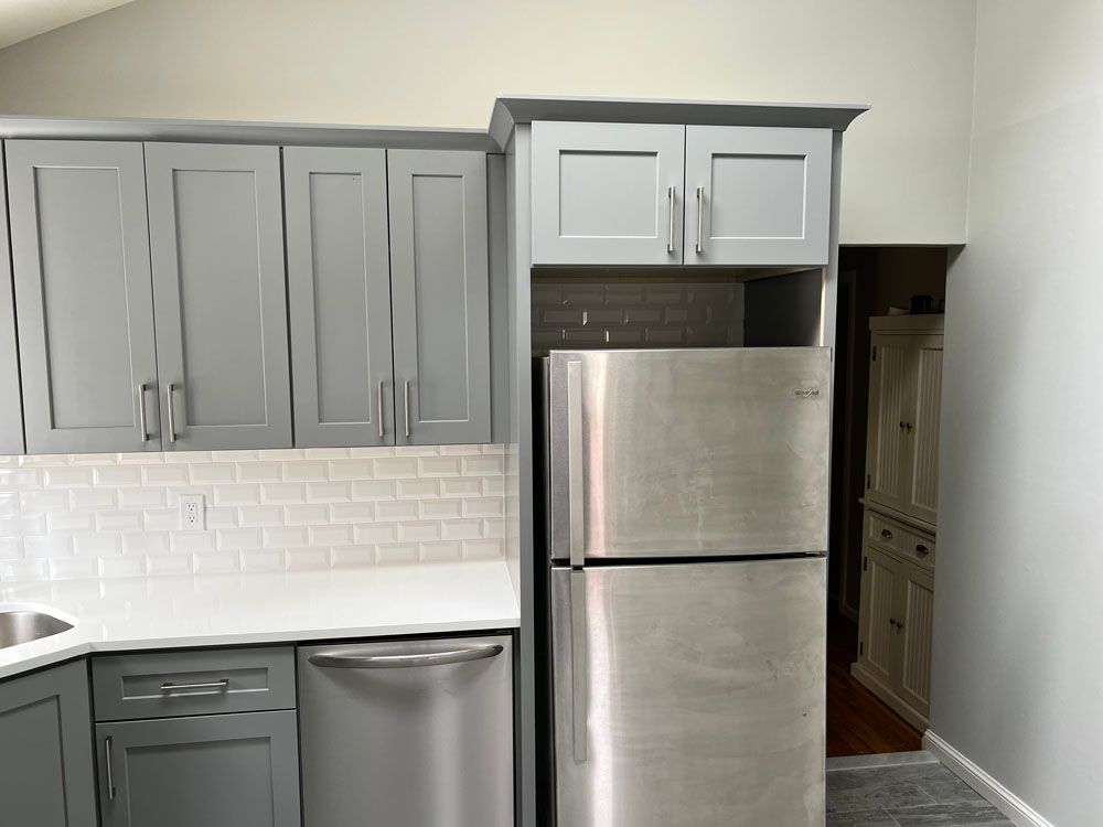 a kitchen with gray cabinets 