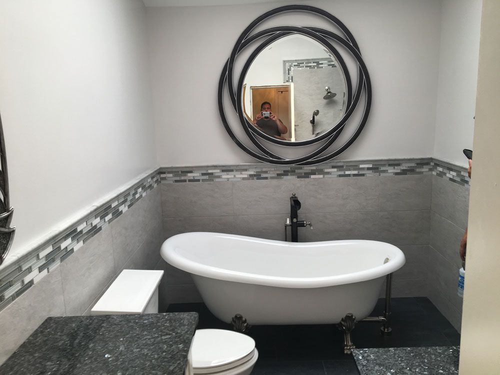 a bathroom with a tub, toilet, sink and mirror