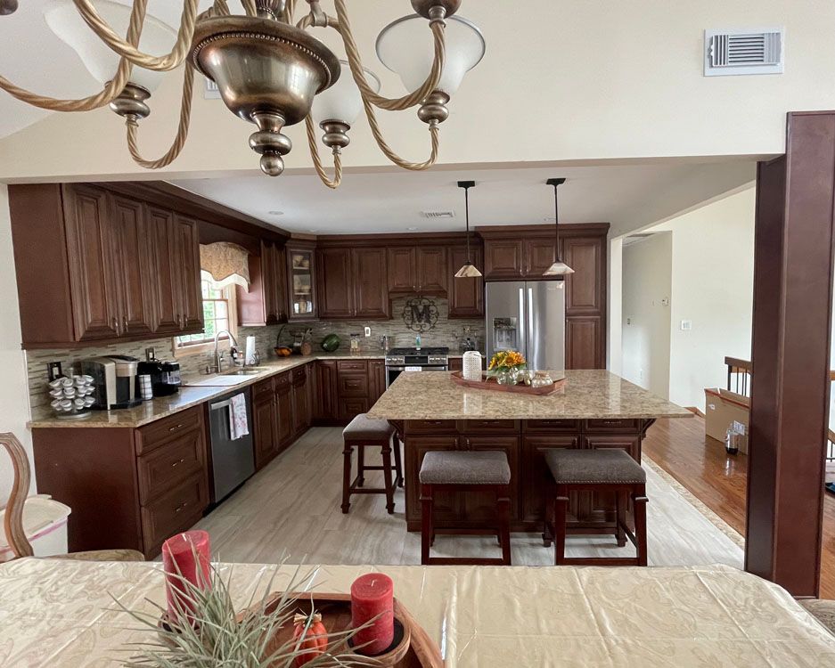 a kitchen with a large island in the middle and a chandelier hanging from the ceiling