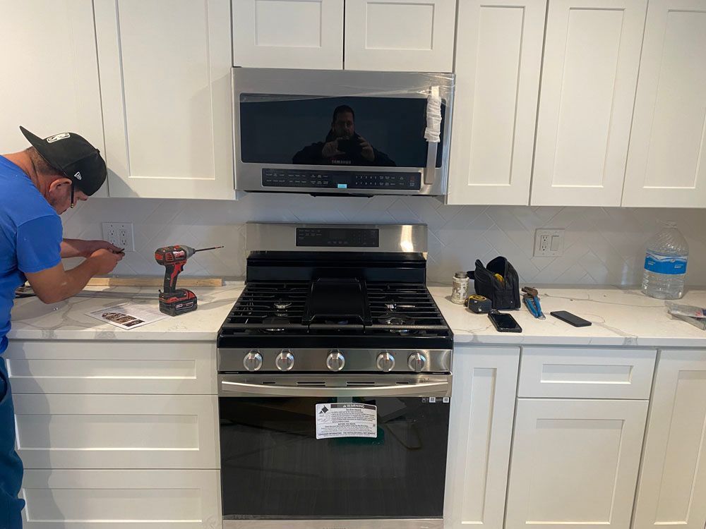 a man is working on a stove in a kitchen