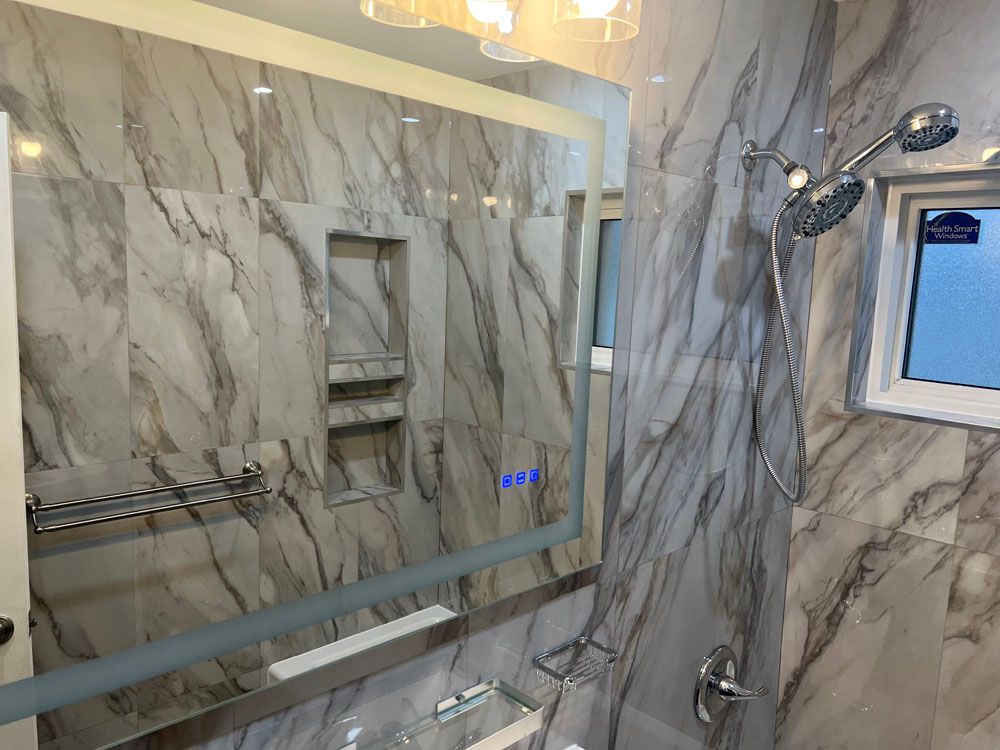 a bathroom with a large mirror and a shower head