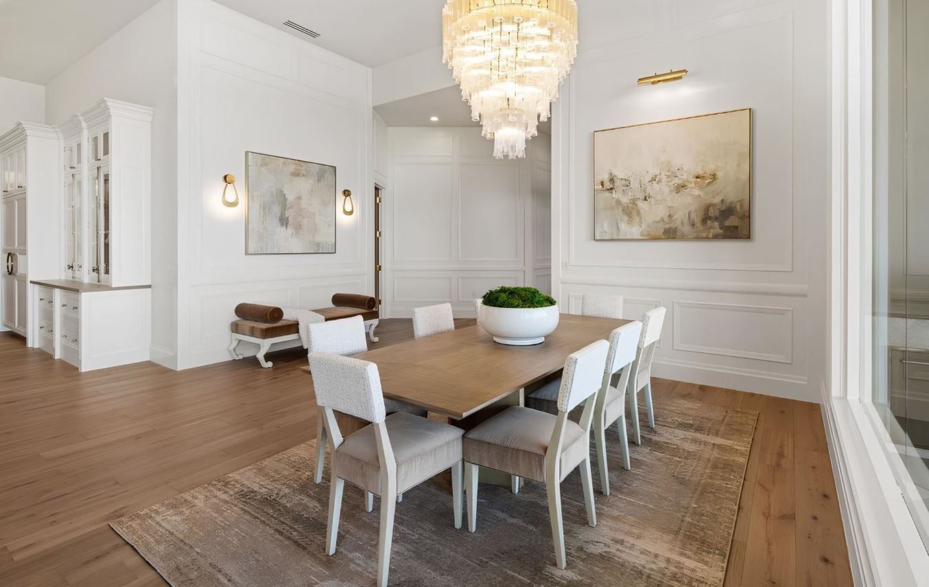 A dining room with a table and chairs and a chandelier.