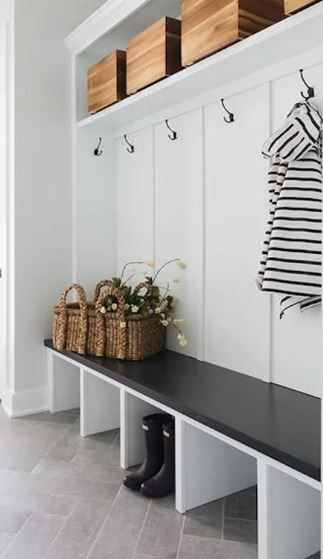 A bench in a hallway with a striped shirt hanging on the wall.