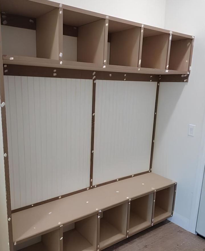 A room with a bench and shelves in it