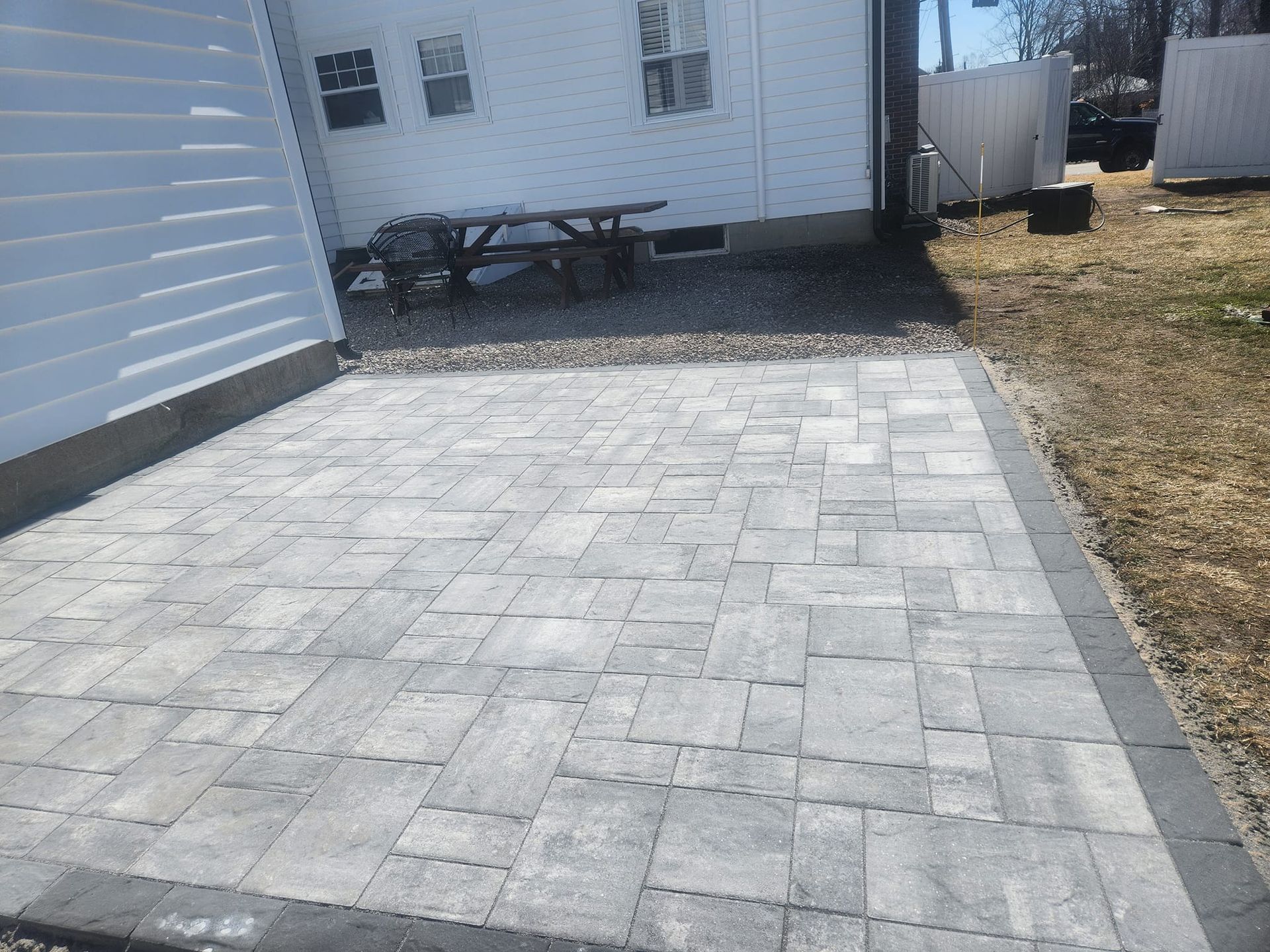 a patio with a picnic table in the backyard of a house