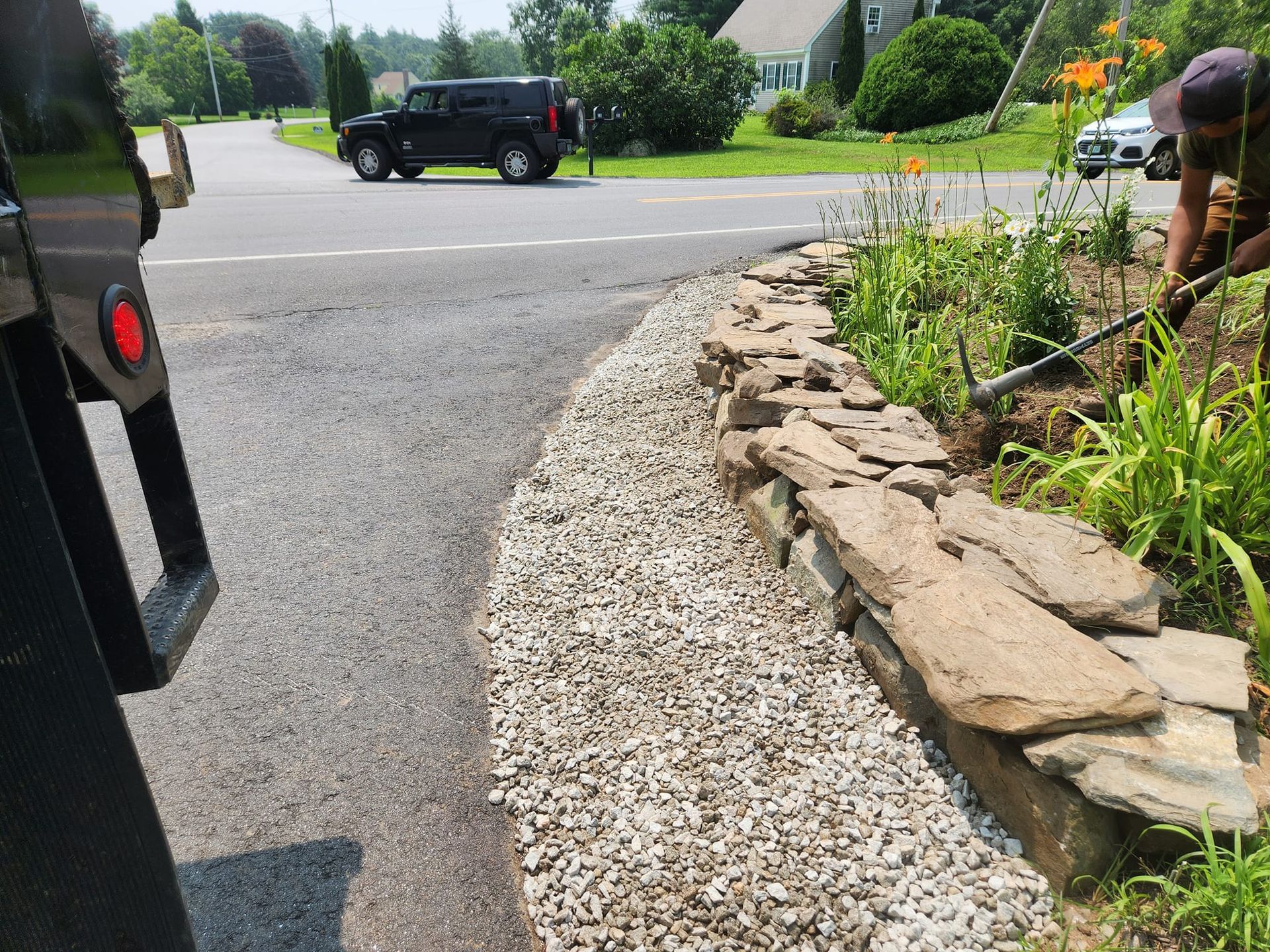 a stone wall next to a road