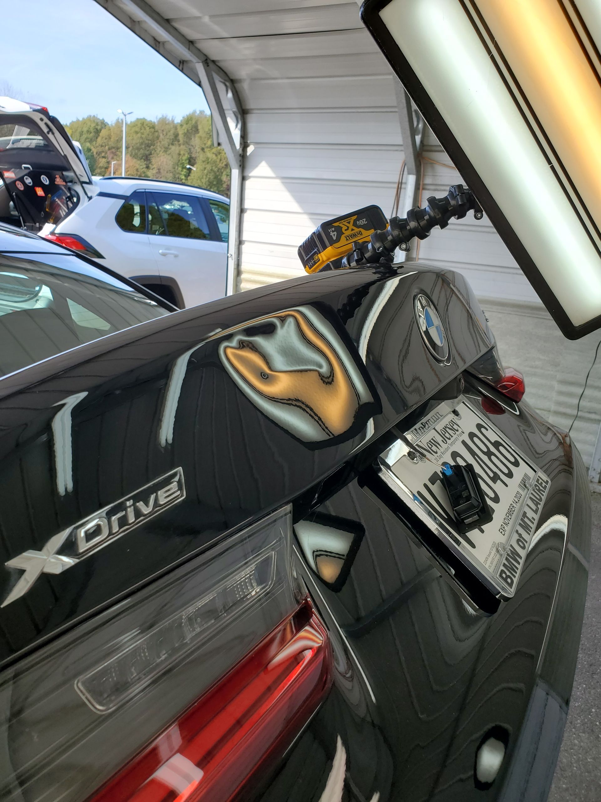 Black racing seat and car interior with a mounted camera, viewed from the back seat