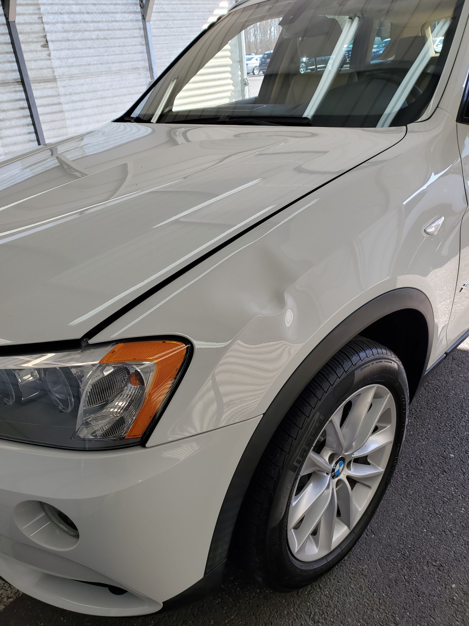 White SUV parked in a garage, front-left view