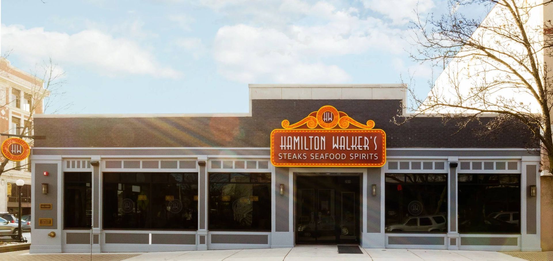 Front view of a white storefront with an orange sign reading “Ranch House” under a blue sky