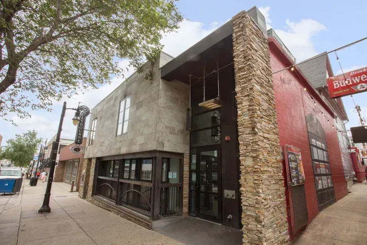 Corner street view of a modern red and stone building with large windows and a Buckwheat sign.