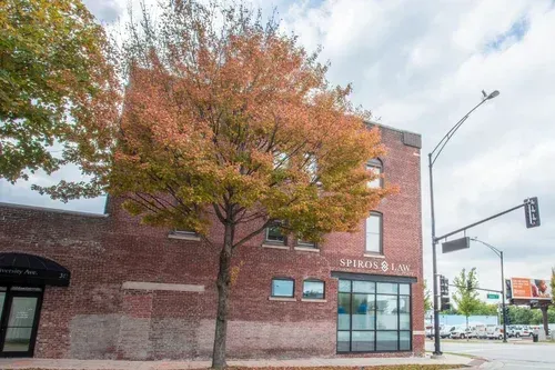Brick building with autumn tree and glass entrance on a city street corner