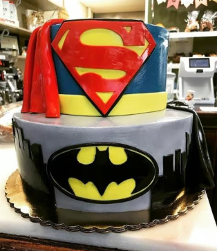 A cake with superman and batman on it