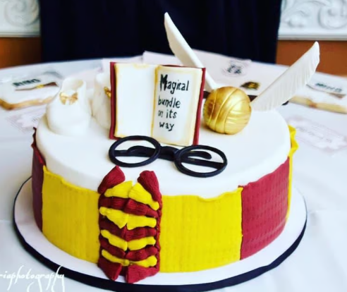 A harry potter cake with a book that says magical bride in its way