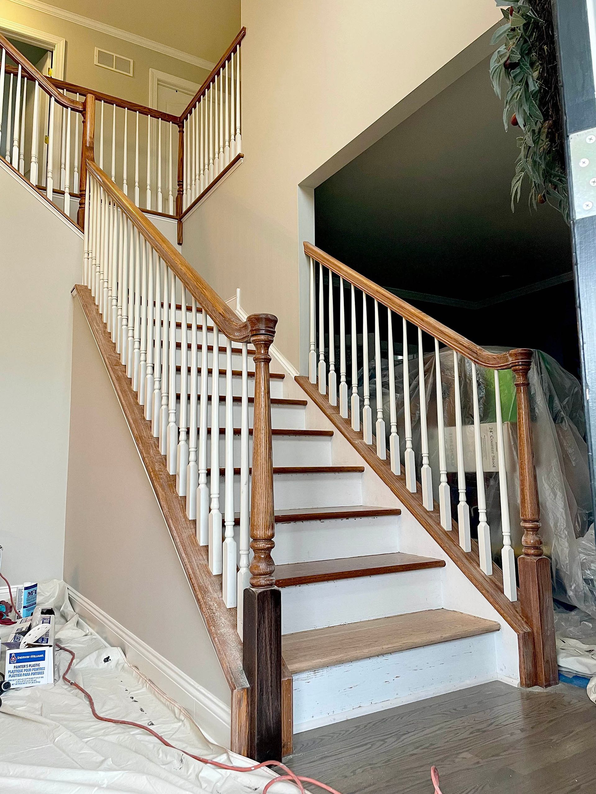 Staircase with white balusters, stained wood handrails and risers, and a neutral wall.