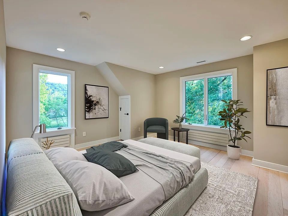Bedroom with large bed, windows, and neutral walls.