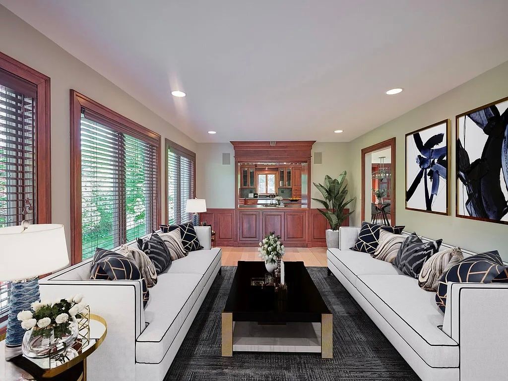 Living room with white sofas, dark coffee table, and wood-paneled bar.
