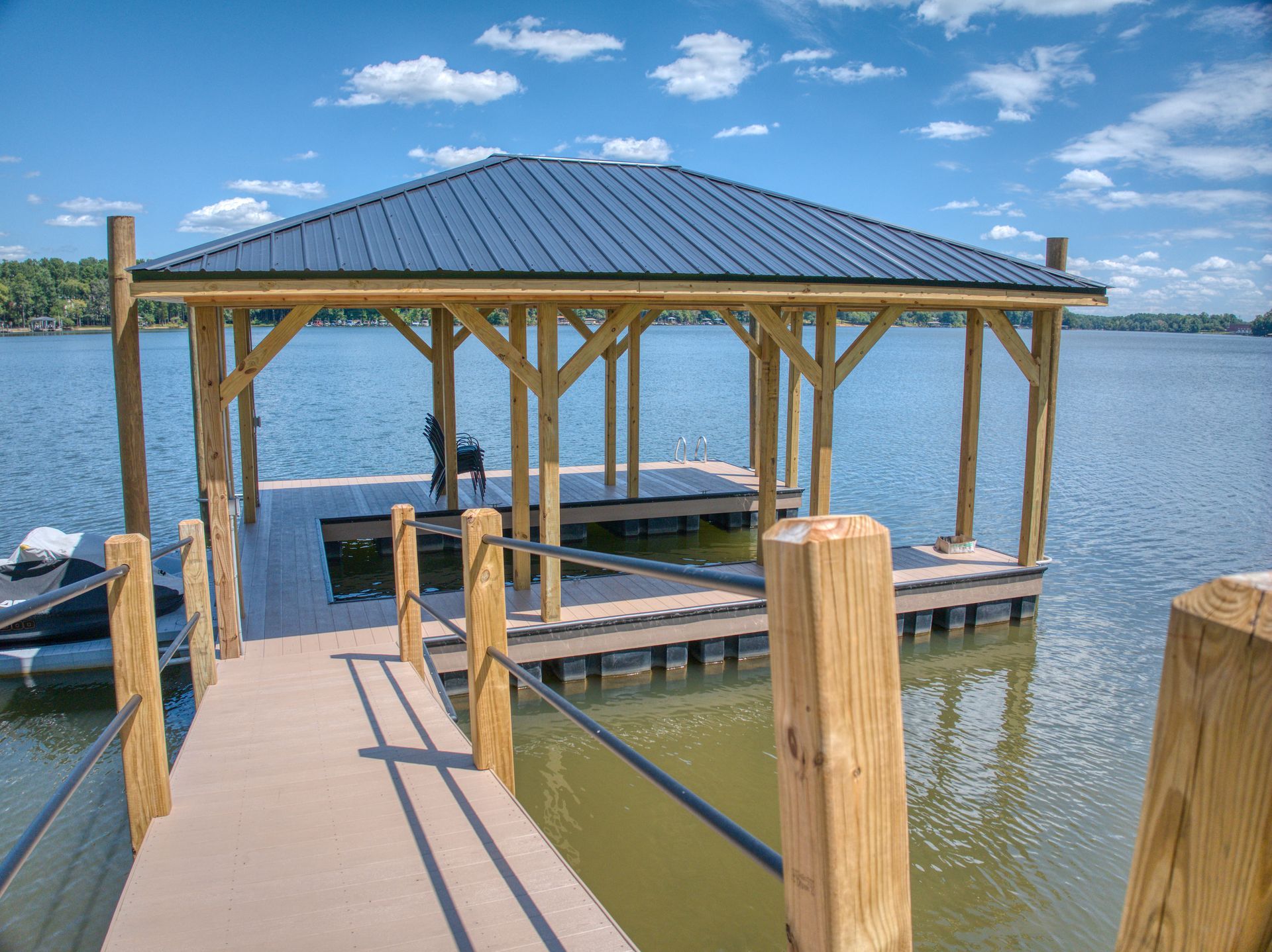Wooden dock with shelter, on a lake, blue sky.