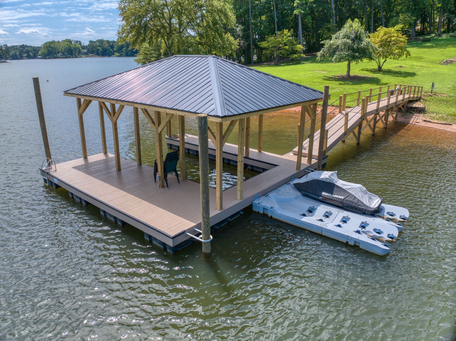 Dock with roof, boat, and walkway on a lake. Brown deck, grey roof, dog visible.