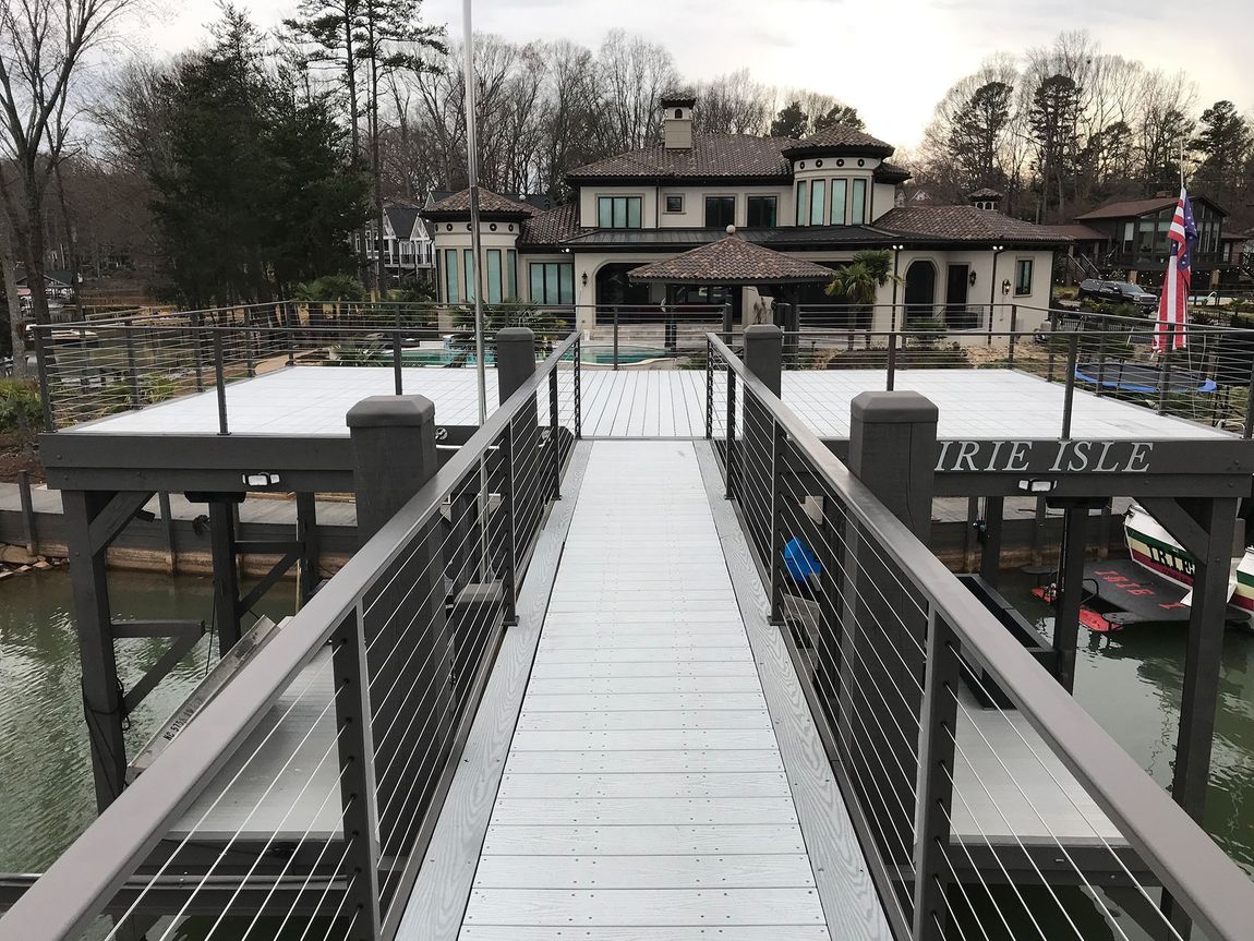A wooden walkway with metal railings leads to a large house on the water; "Marie Isle" is written.