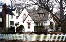 A white house with a white picket fence around it.