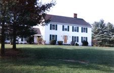 A large white house with a large lawn in front of it.