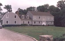 A large house with a car parked in front of it.