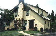 A large house with a lot of windows and a chimney.