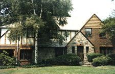 Two houses are sitting next to each other on a lush green lawn.