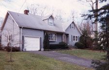 A house with a garage and a driveway in front of it.