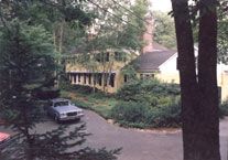 A car is parked in a driveway in front of a house.