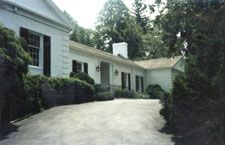 A large white house with a long driveway leading to it.