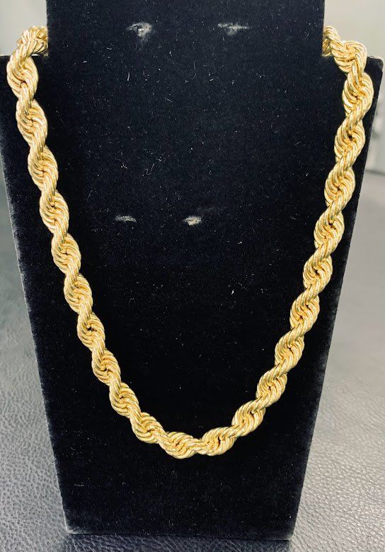 A gold chain is on a black mannequin