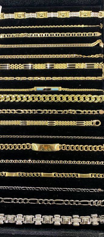 A bunch of gold chains are lined up on a black surface.