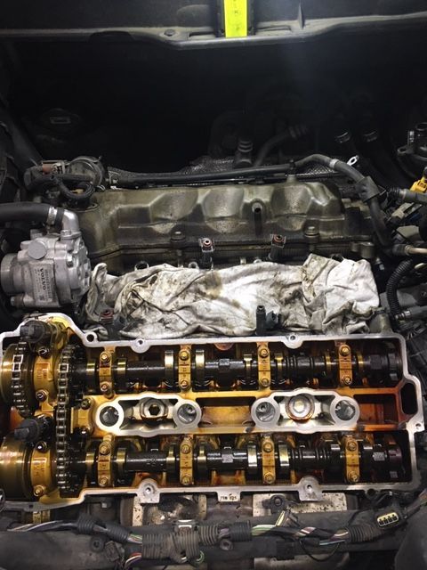 Open car engine with exposed camshafts and timing chain during repair