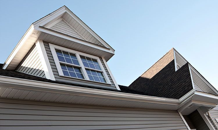 looking up at the roof of a house with a window
