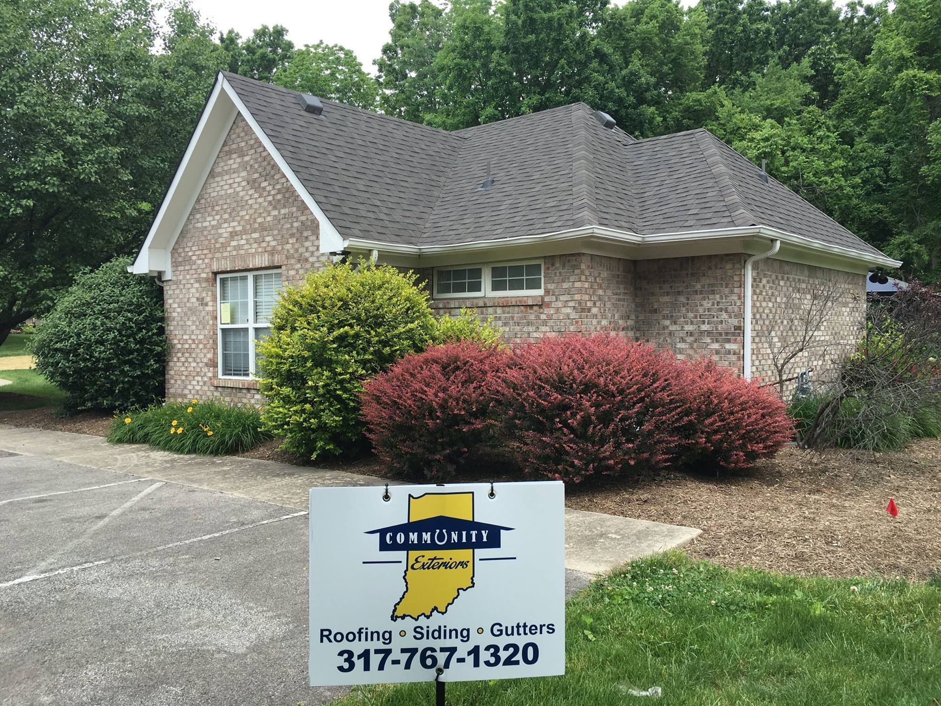 a brick house with a sign in front of it