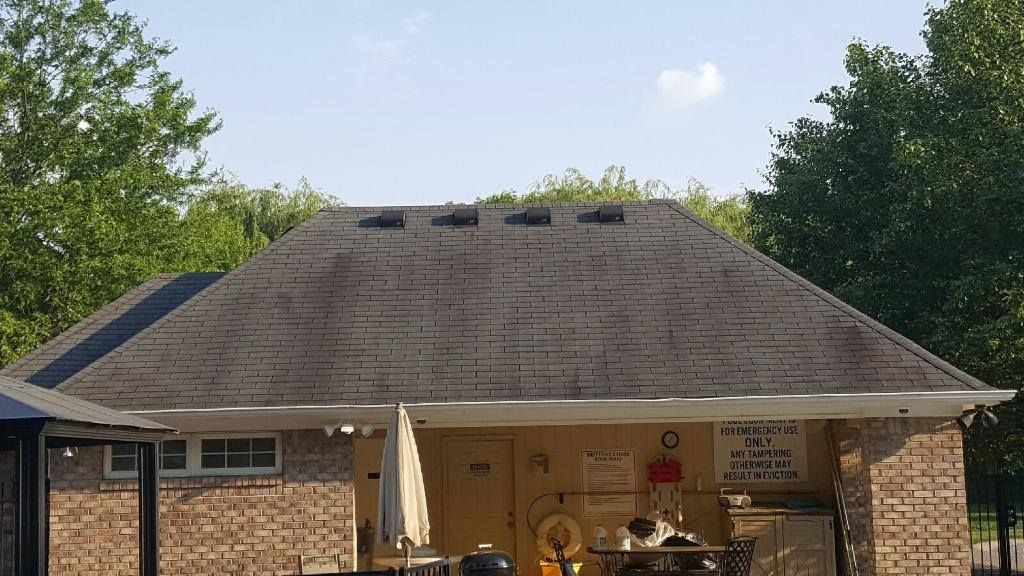 a brick house with a large roof and a patio area