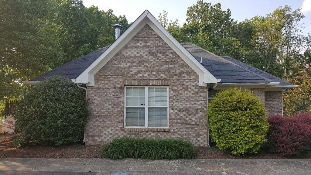a small brick house with a roof and a window