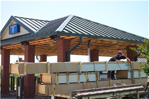 A man is working on the roof of a building that has the letter t on it